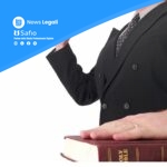 Professionista legale con mano su Bibbia, rappresentazione simbolica della prova testimoniale nel diritto
