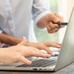 Professionista digitale consulta documentazione legale su laptop per analisi normativa e prescrizione