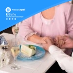 Coppia di sposi scambiano anelli durante cerimonia matrimoniale con torta nuziale