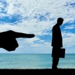 Silhouette uomo d'affari allontanato dal lavoro, mobbing e discriminazione sul lavoro, danno professionale