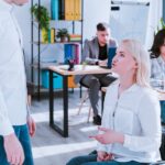 Riunione di lavoro in ufficio moderno con professionisti che discutono di diritti e tutele lavorative