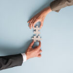 Due mani assemblano un puzzle, simbolo di soluzione legale e accordo professionale