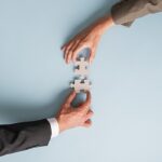 Due mani che uniscono un puzzle rappresentando il bilanciamento tra creditori e azienda in crisi