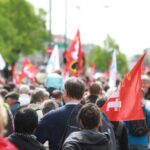Manifestazione pubblica con bandiere rosse in ambito di diritto del lavoro pubblico e contratti collettivi