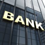 Insegna BANK in oro su facciata moderna, simbolo di istituto bancario per credito e finanziamenti