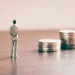 Banconota arrotolata con monete impilate simbolo di ammortamento mutuo e interessi finanziari