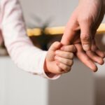 Bambina che stringe la mano del padre in segno di fiducia e protezione legale familiare