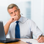 Professionista legale al lavoro su laptop con documenti di processo esecutivo