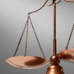 Bilancia della giustizia in rame con piatti equilibrati su sfondo neutro, simbolo di equità legale