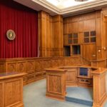 Aula di tribunale in legno con banchi e scrivania, simbolo di giustizia e procedura civile