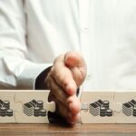 Mano che assembla puzzle con simboli di denaro e monete, rappresentando successione ereditaria e divisione quote