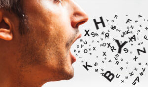 Uomo che parla con lettere e simboli che escono dalla bocca, rappresentazione della comunicazione verbale e linguaggio