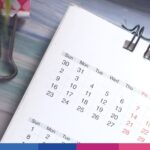Calendario da scrivania con spirale metallica e date mesi visualizzate su piano di lavoro