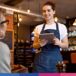 Cameriera con tablet prende ordine cliente al bancone del ristorante moderno