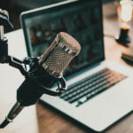 Studio di registrazione podcast con microfono professionale e laptop per consulenze legali e fiscali